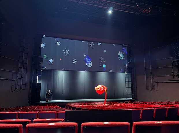 ステージに取りつけられたスクリーンには、人々がつくった雪の結晶が流されていた。ワークショップの企画や映像化はインタラクティブ・アート・ユニット、フジ森が手がけた。