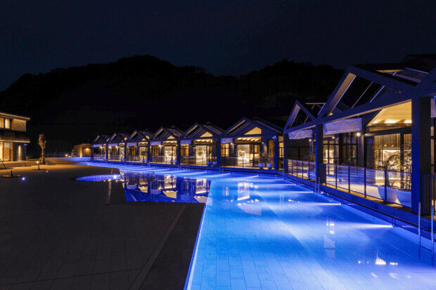 温泉プールは夜になると青くライトアップされ、幻想的な雰囲気に。