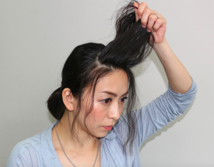 前髪全体にクセがついた状態で、生え際からひし形に毛束を取ります。