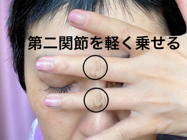 中指と薬指の第二関節を眉間と鼻骨の中央にそっと置きます