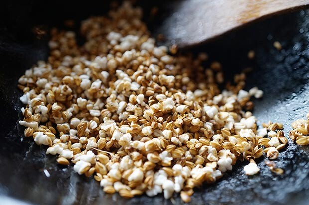 フライパンで炒っている籾付きのお米の写真
