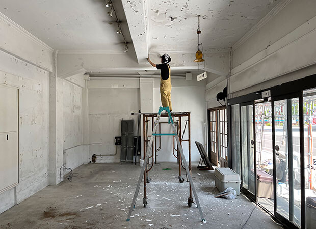 内部の工事は旧昆布館の１階から。新たに事務所に加わった大建綾ちゃんが天井や壁のペンキを擦り落とし、化粧直しを進める。