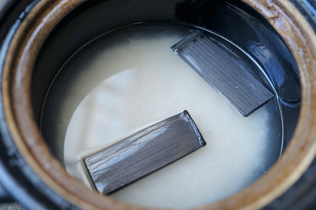 浸水中のお米に竹炭を浮かべている写真