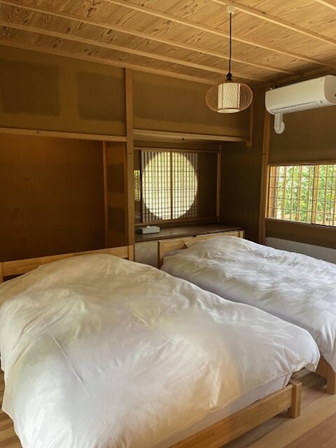 丸窓や照明、格子窓とが映えるベッドルーム。