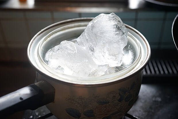 ホーロー鍋の蓋を逆さにして、蓋の上に氷を置いている写真。