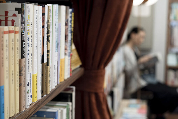 本が並ぶ奥に本を読むお客さん