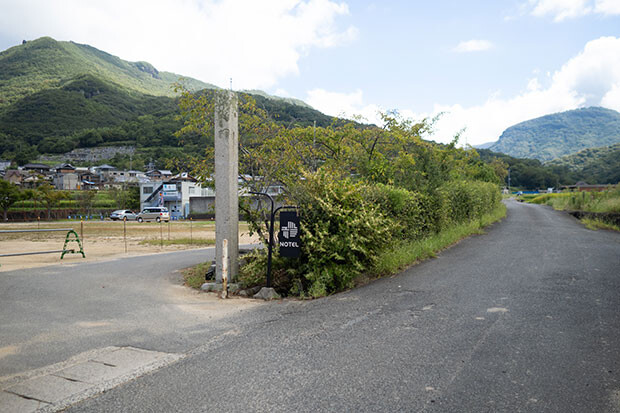 車でお越しの方は、NOTEL看板がある石柱のところから敷地へ。写真左のグラウンドの方に進んでいきます。
