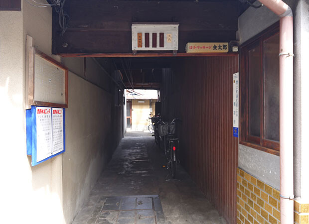 トンネル路地を見る。奥の正面に見える建物が今回の物件。