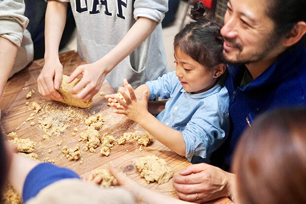 女の子が味噌の材料を混ぜている写真。