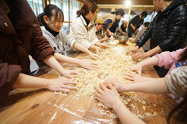 女性たちが味噌の材料を混ぜている写真。