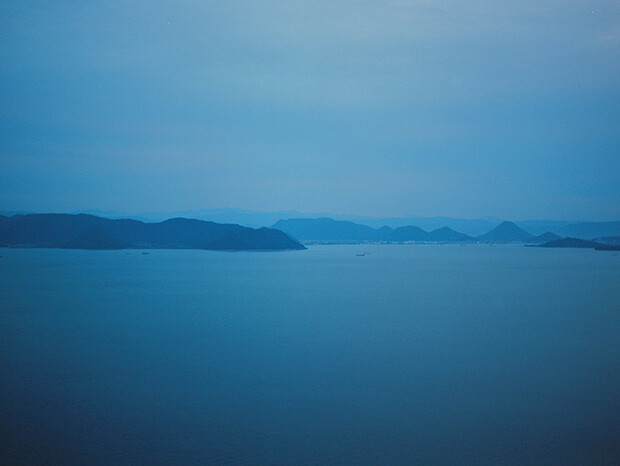 遠くに島々が連なる、児島の海の風景写真。