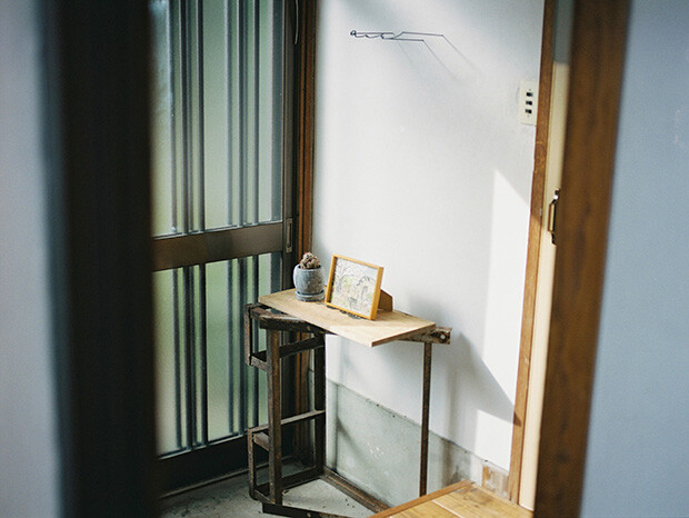 〈aru〉と書かれた金属製の看板と、植物や額が置かれた店舗の玄関の写真。