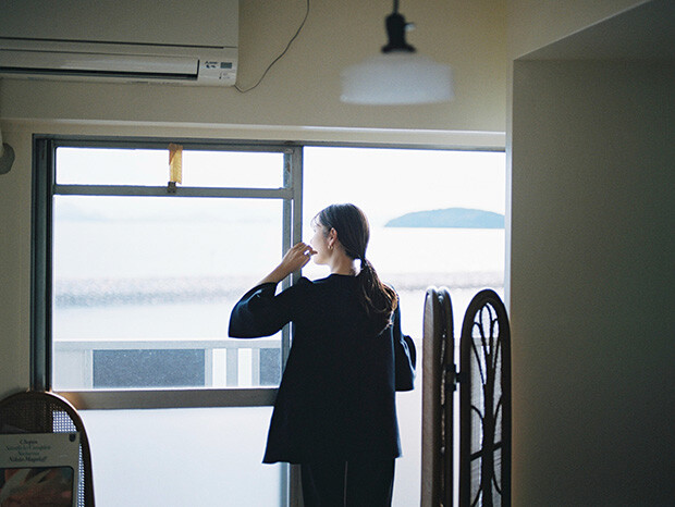 ベランダから海の望むあかしさんの後ろ姿の写真。
