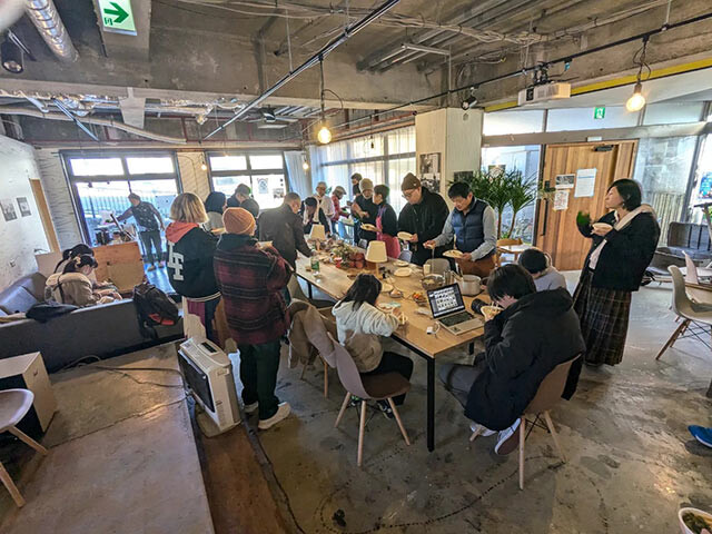 施設内の大きなテーブルを囲んだ餅つきイベントの様子