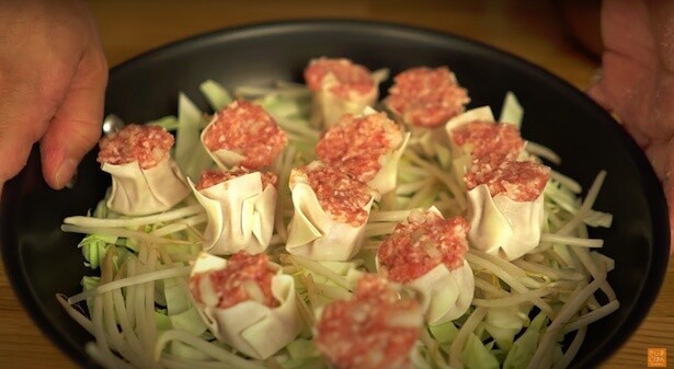野菜を敷き詰めたフライパンに焼売を並べる