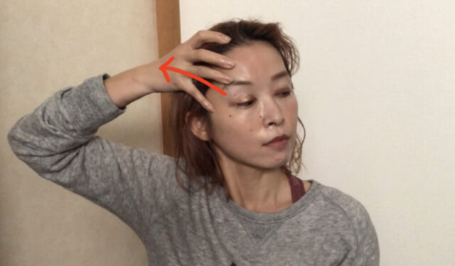 2回繰り返したら、こめかみあたりに指をずらして先ほどと同じように生え際に向かって指をスライドさせます。これも2回行います