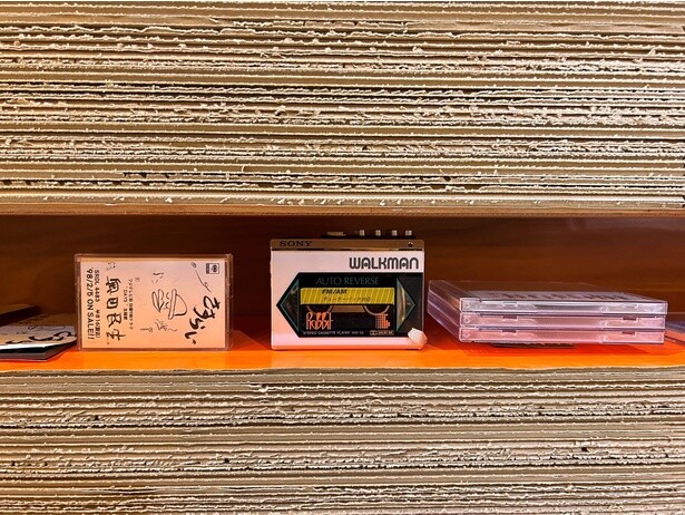 地層に見立てられた壁面の段ボールの間には、音楽や創作にまつわるグッズが置かれている