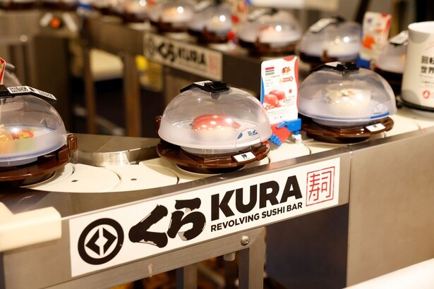寿司と各国・地域の料理が手をつないでベルト上を流れる