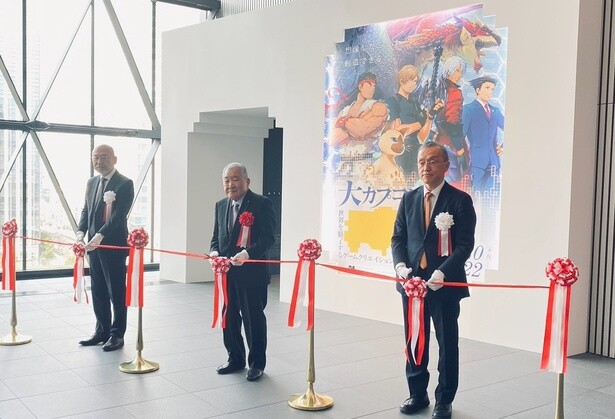 テープカットに参加する菅谷さん(左)、カプコン 代表取締役会長兼最高経営責任者の辻本憲三さん(中央)、読売新聞大阪本社 代表取締役社長の田中隆之さん(右)