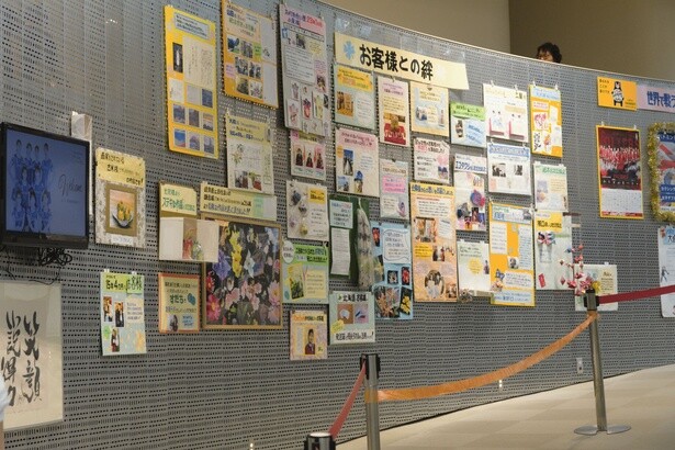 2階から1階へ下りていくスロープに飾られた「お客様との絆」は、会員から贈られた手紙や手作りの品々を展示