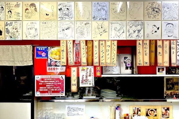 多くの漫画家たちのサインが並ぶ。自身のサインとともに「ンマーイ」も文字が！