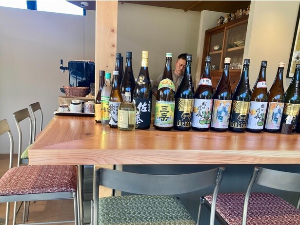 「城下町カフェ 魚久」の店内。カウンターには酒瓶がズラリ！