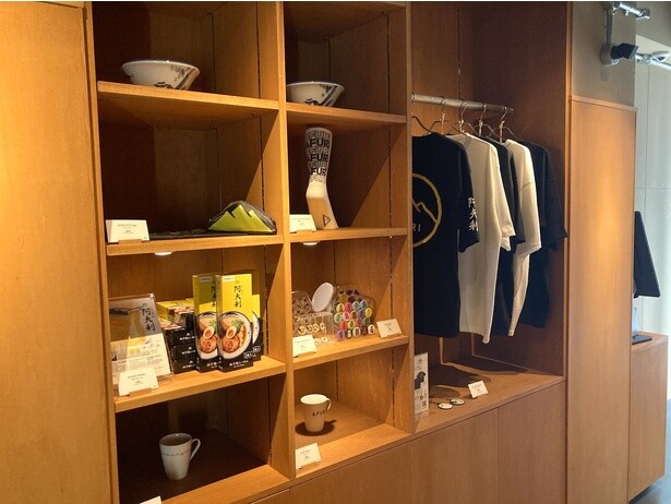 店頭では缶バッジやマグカップ、韓国アパレルとのコラボTシャツといったグッズを販売