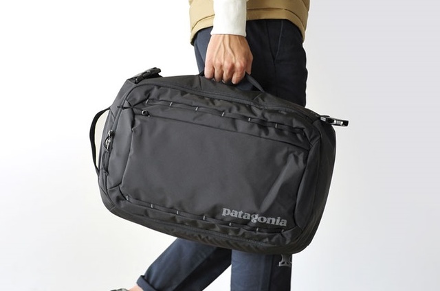 patagoniaの黒いビジネスバッグを持った人